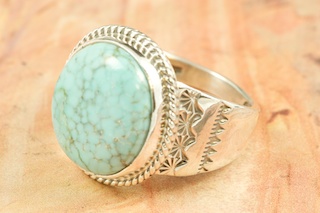 Genuine Number 8 Turquoise set in Sterling Silver Ring. The Number 8 mine is located in Eureka County Nevada. Since 1976 there has been no Number 8 Turquoise mined. There is however, an existing stock pile that Mr. Dowell Ward, the last owner of the Number 8 mine, had stocked away for later sorting. The Turquoise is a collector's item--because once the reserve is gone there will be no more material released onto the market. The Gold Mining Company owns the claim to the Number 8 mine and it has been swallowed up by the gold mining operations. This is some of the last Number 8 Turquoise to be had and will be a great addition to your collection. Created by Navajo Artist Tony Garcia. Signed by the artist.

