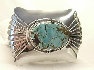 Genuine Number 8 Mine Turquoise Stone set in Sterling Silver Belt Buckle. Created by Navajo Artist John Nelson. Signed. The Number 8 mine is located in Eureka County Nevada. Since 1976 there has been no Number 8 Turquoise mined. There is however, an existing stock pile that Mr. Dowell Ward, the last owner of the Number 8 mine, had stocked away for later sorting. The Turquoise is a collector's item--because once the reserve is gone there will be no more material released onto the market. The Gold Mining Company owns the claim to the Number 8 mine and it has been swallowed up by the gold mining operations. This is some of the last Number 8 Turquoise to be had and will be a great addition to your collection. 