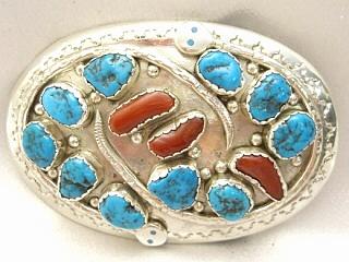 Authentic Native American Jewelry. Genuine Sleeping Beauty Turquoise and Blood Red Coral Set in Heavy Gauge Sterling Silver. This Stunning Belt Buckle was Created by Zuni Artist Effie Calavaza.
A signature trademark of Effie's is the snake symbol, entwined around Turquoise and Coral on Sterling Silver.
Signed Effie C. Zuni.
