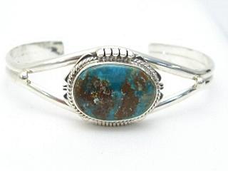 Genuine Royston Turquoise set in Sterling Silver Bracelet. The Royston Turquoise Mine was originally known as the Royal Blue Mine. It produces Turquoise that has a mixture of blues and greens in the same formation. The Royston Turquoise Mine is located in Nye County, Nevada. Created by Navajo Artist Kathy Yazzie. Signed. 