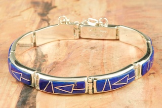 Genuine Boulder Turquoise set in Sterling Silver Bracelet. The cabochon is Boulder Turquoise, you can see the veins of Turquoise running through the host rock. The Boulder Turquoise Mine is located in northeast Nevada. It was discovered in 1970 by a Shoshone sheep herder. Production is small due to the remote location and winter weather. Boulder Turquoise is valued for both it's beauty and rarity. Every stone is unique. Created by Navajo Artist Kathy Yazzie. Signed.