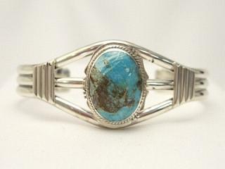 Genuine Sunnyside Turquoise set in Sterling Silver Bracelet. The matrix on this rare stone is outstanding. The Sunnyside mine is located in northern Nevada near the town of Tuscarora in the Tuscarora mountain range. The mine is no longer in operation as it has become part of a gold mining operation and a privately owned ranch. The Sunnyside mine was mined mostly in the 70's. You won't find much of this great turquoise around anymore except for old stashes. Created by Navajo Artist Larson Lee. Signed.