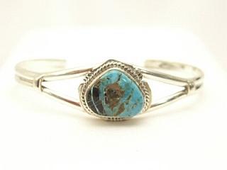 Genuine Sunnyside Turquoise set in Sterling Silver Bracelet. The matrix on this rare stone is outstanding. The Sunnyside mine is located in northern Nevada near the town of Tuscarora in the Tuscarora mountain range. The mine is no longer in operation as it has become part of a gold mining operation and a privately owned ranch. The Sunnyside mine was mined mostly in the 70's. You won't find much of this great turquoise around anymore except for old stashes. Created by Navajo Artist Kathy Yazzie. Signed.