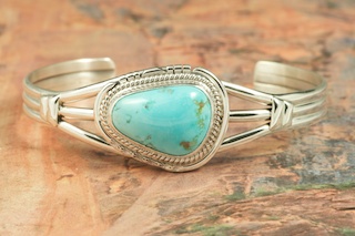 Genuine Castle Dome Turquoise set in Sterling Silver Bracelet. The Castle Dome Turquoise Mine is located about 30 miles from the Sleeping Beauty Mine, near Globe, Arizona. The Castle Dome Mine has not been in operation since the early 1970s. Created by Navajo Artist Arkie Nelson. Signed by the artist.