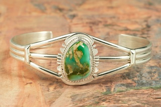 Genuine Royston Turquoise set in Sterling Silver Bracelet. The Royston Turquoise Mine was originally known as the Royal Blue Mine. It produces Turquoise that has a mixture of blues and greens in the same formation. The Royston Turquoise Mine is located in Nye County, Nevada. Created by Navajo Artist Phillip Sanchez. Signed by the artist.