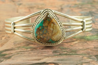 Genuine Royston Turquoise set in Sterling Silver Bracelet. The Royston Turquoise Mine was originally known as the Royal Blue Mine. It produces Turquoise that has a mixture of blues and greens in the same formation. The Royston Turquoise Mine is located in Nye County, Nevada. Created by Navajo Artist Margaret Platero. Signed by the artist.