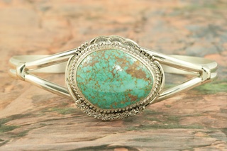 Genuine Royston Turquoise set in Sterling Silver Bracelet. The Royston Turquoise Mine was originally known as the Royal Blue Mine. It produces Turquoise that has a mixture of blues and greens in the same formation. The Royston Turquoise Mine is located in Nye County, Nevada. Created by Navajo Artist John Nelson. Signed by the artist.
