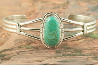Genuine Number 8 Turquoise set in Sterling Silver Bracelet. The Number 8 mine is located in Eureka County Nevada. Since 1976 there has been no Number 8 Turquoise mined. There is however, an existing stock pile that Mr. Dowell Ward, the last owner of the Number 8 mine, had stocked away for later sorting. The Turquoise is a collector's item--because once the reserve is gone there will be no more material released onto the market. The Gold Mining Company owns the claim to the Number 8 mine and it has been swallowed up by the gold mining operations. This is some of the last Number 8 Turquoise to be had and will be a great addition to your collection. Created by Navajo Artist Milton Lee. Signed by the artist.
