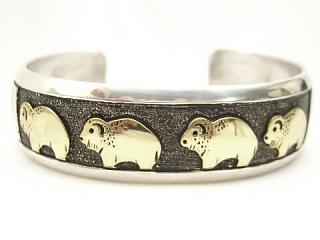 Stunning heavy gauge Sterling Silver Bracelet with Buffalo Designs. Beautiful 12K Gold Buffalo overlay. Created by Navajo Artist Tommy Singer. Signed 
