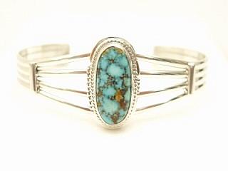 Genuine Kingman Turquoise set in heavy gauge Sterling Silver Bracelet. The Kingman Turquoise Mine is located in Mohave County, Arizona. Created by Navajo Artist Larson Lee. Signed.