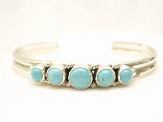 Genuine Number 8 Turquoise set in Sterling Silver. Stunning heavy gauge Sterling Silver Bracelet with 5 Beautiful Turquoise Stones. The Number 8 mine is located in Eureka County Nevada. Since 1976 there has been no Number 8 Turquoise mined. There is however, an existing stock pile that Mr. Dowell Ward, the last owner of the Number 8 mine, had stocked away for later sorting. The Turquoise is a collector's item--because once the reserve is gone there will be no more material released onto the market. The Gold Mining Company owns the claim to the Number 8 mine and it has been swallowed up by the gold mining operations. This is some of the last Number 8 Turquoise to be had and will be a great addition to your collection. Created by Navajo Artist Milton Lee. Signed. 
