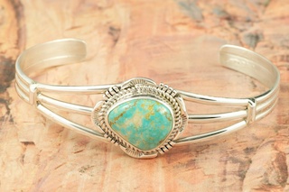 Genuine Number 8 Mine Turquoise Stone set in Sterling Silver Bracelet. Created by Navajo Artist Kathy Yazzie. The Number 8 mine is located in Eureka County Nevada. Since 1976 there has been no Number 8 Turquoise mined. There is however, an existing stock pile that Mr. Dowell Ward, the last owner of the Number 8 mine, had stocked away for later sorting. The Turquoise is a collector's item--because once the reserve is gone there will be no more material released onto the market. The Gold Mining Company owns the claim to the Number 8 mine and it has been swallowed up by the gold mining operations. This is some of the last Number 8 Turquoise to be had and will be a great addition to your collection. 