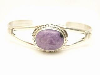 Genuine Charoite set in heavy gauge Sterling Silver Bracelet. Created by Navajo Artist Larson Lee. Charoite is a Beautiful and interesting gemstone first introduced in the US around 1976. It's vivid colors range from lavender to deep chatoyant purple. It is mined in Siberia Russia near Charo River, Lake Baikal region. High grade charoite is distinguished by mixtures of deep rich purple and silky zones, in swirly and/or needle-like chatoyant patterns/sprays. 