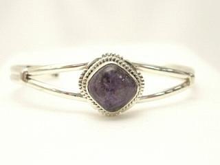 Genuine Charoite set in Sterling Silver Bracelet. Created by Navajo Artist Johnny Johnson. Charoite is a Beautiful and interesting gemstone first introduced in the US around 1976. It's vivid colors range from lavender to deep chatoyant purple. It is mined in Siberia Russia near Charo River, Lake Baikal region. High grade charoite is distinguished by mixtures of deep rich purple and silky zones, in swirly and/or needle-like chatoyant patterns/sprays. 