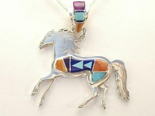 Genuine Turquoise, Spiny Oyster Shell, Sugilite, Blue Lapis and Black Jade inlaid between ribbons of Sterling Silver. Horse Pendant features beautiful inlay work on the bale. Designed by Navajo Artist Calvin Begay. Signed.