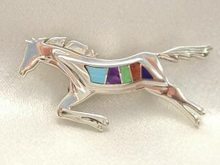 Genuine Turquoise, Sugilite, Spiny Oyster Shell and Jet inlaid between ribbons of Sterling Silver. Jumping Horse Brooch Created by Navajo Artist Calvin Begay.