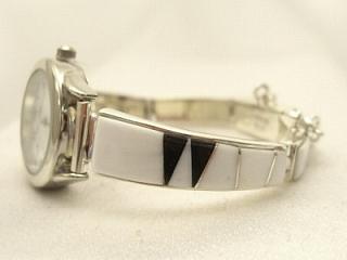 White Buffalo Turquoise and Black Jade inlaid between ribbons of Sterling Silver. Stunning Ladies Quartz Watch Bracelet with precision channel inlay. Designed by Navajo Artist Calvin Begay. Signed. 