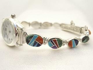 Stunning Watch Bracelet with Genuine Sleeping Beauty Turquoise, Spider Web Turquoise, Spiny Oyster Shell and Blue Lapis inlaid between ribbons of Sterling Silver. Designed by Navajo Artist Calvin Begay. Signed. 