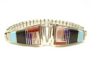 Genuine Turquoise, Mother of Pearl, Coral and Black Jade inlaid between ribbons of Sterling Silver. Ladies Watch Tip with expandable band. Created by Zuni Artist Chester Shondene Lonjose. Signed 
