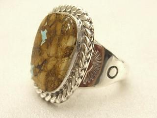 Genuine Boulder Turquoise set in Sterling Silver Ring. The cabachons are of Boulder Turquoise, you can see the veins of Turquoise running through the host rock. The Boulder Turquoise Mine is located in northeast Nevada. It was discovered in 1970 by a Shoshone sheep herder. Production is small due to the remote location and winter weather. Boulder Turquoise is valued for both it's beauty and rarity. Every stone is unique. Created by Navajo Artist Phillip Sanchez.