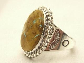 Genuine Boulder Turquoise set in Sterling Silver Ring. The cabachons are of Boulder Turquoise, you can see the veins of Turquoise running through the host rock. The Boulder Turquoise Mine is located in northeast Nevada. It was discovered in 1970 by a Shoshone sheep herder. Production is small due to the remote location and winter weather. Boulder Turquoise is valued for both it's beauty and rarity. Every stone is unique. Created by Navajo Artist Phillip Sanchez. Signed.
