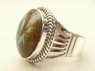 Genuine Number 8 Turquoise set in Sterling Silver Ring. The Number 8 mine is located in Eureka County Nevada. Since 1976 there has been no Number 8 Turquoise mined. There is however, an existing stock pile that Mr. Dowell Ward, the last owner of the Number 8 mine, had stocked away for later sorting. The Turquoise is a collector's item--because once the reserve is gone there will be no more material released onto the market. The Gold Mining Company owns the claim to the Number 8 mine and it has been swallowed up by the gold mining operations. This is some of the last Number 8 Turquoise to be had and will be a great addition to your collection. Created by Navajo Artist Larson Lee. Signed.
