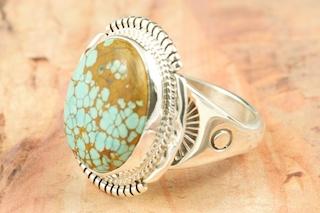 Genuine Number 8 Turquoise set in Sterling Silver Ring. The Number 8 mine is located in Eureka County Nevada. Since 1976 there has been no Number 8 Turquoise mined. There is however, an existing stock pile that Mr. Dowell Ward, the last owner of the Number 8 mine, had stocked away for later sorting. The Turquoise is a collector's item--because once the reserve is gone there will be no more material released onto the market. The Gold Mining Company owns the claim to the Number 8 mine and it has been swallowed up by the gold mining operations. This is some of the last Number 8 Turquoise to be had and will be a great addition to your collection. Created by Navajo Artist John Nelson. Signed by the artist.