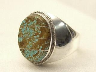 Genuine Number 8 Turquoise set in Sterling Silver Ring. The Number 8 mine is located in Eureka County Nevada. Since 1976 there has been no Number 8 Turquoise mined. There is however, an existing stock pile that Mr. Dowell Ward, the last owner of the Number 8 mine, had stocked away for later sorting. The Turquoise is a collector's item--because once the reserve is gone there will be no more material released onto the market. The Gold Mining Company owns the claim to the Number 8 mine and it has been swallowed up by the gold mining operations. This is some of the last Number 8 Turquoise to be had and will be a great addition to your collection. Created by Navajo Artist Freddy Charley. Signed. 
