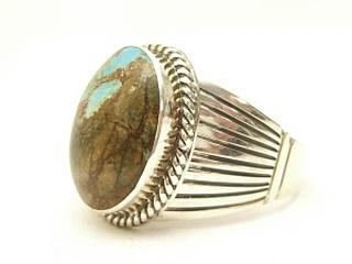 Genuine Number 8 Turquoise set in Sterling Silver Ring. The Number 8 mine is located in Eureka County Nevada. Since 1976 there has been no Number 8 Turquoise mined. There is however, an existing stock pile that Mr. Dowell Ward, the last owner of the Number 8 mine, had stocked away for later sorting. The Turquoise is a collector's item--because once the reserve is gone there will be no more material released onto the market. The Gold Mining Company owns the claim to the Number 8 mine and it has been swallowed up by the gold mining operations. This is some of the last Number 8 Turquoise to be had and will be a great addition to your collection. Created by Navajo Artist Larson Lee. Signed.