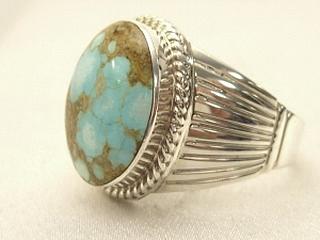 Genuine Number 8 Turquoise set in Sterling Silver Ring. The Number 8 mine is located in Eureka County Nevada. Since 1976 there has been no Number 8 Turquoise mined. There is however, an existing stock pile that Mr. Dowell Ward, the last owner of the Number 8 mine, had stocked away for later sorting. The Turquoise is a collector's item--because once the reserve is gone there will be no more material released onto the market. The Gold Mining Company owns the claim to the Number 8 mine and it has been swallowed up by the gold mining operations. This is some of the last Number 8 Turquoise to be had and will be a great addition to your collection. Created by Navajo Artist Larson Lee. Signed.