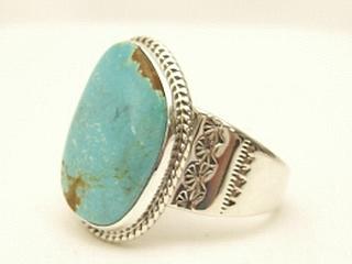 Genuine Number 8 Turquoise set in Sterling Silver Ring. The Number 8 mine is located in Eureka County Nevada. Since 1976 there has been no Number 8 Turquoise mined. There is however, an existing stock pile that Mr. Dowell Ward, the last owner of the Number 8 mine, had stocked away for later sorting. The Turquoise is a collector's item--because once the reserve is gone there will be no more material released onto the market. The Gold Mining Company owns the claim to the Number 8 mine and it has been swallowed up by the gold mining operations. This is some of the last Number 8 Turquoise to be had and will be a great addition to your collection. Created by Navajo Artist Tony Garcia. Signed.
