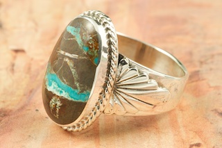 Genuine Sunnyside Turquoise set in Sterling Silver Ring. The matrix on this rare stone is outstanding. The Sunnyside mine is located in northern Nevada near the town of Tuscarora in the Tuscarora mountain range. The mine is no longer in operation as it has become part of a gold mining operation and a privately owned ranch. The Sunnyside mine was mined mostly in the 70's. You won't find much of this great turquoise around anymore except for old stashes. Created by Navajo Artist Phillip Sanchez. Signed by the artist.

