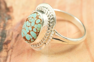 Genuine Number 8 Turquoise set in Sterling Silver Ring. The Number 8 mine is located in Eureka County Nevada. Since 1976 there has been no Number 8 Turquoise mined. There is however, an existing stock pile that Mr. Dowell Ward, the last owner of the Number 8 mine, had stocked away for later sorting. The Turquoise is a collector's item--because once the reserve is gone there will be no more material released onto the market. The Gold Mining Company owns the claim to the Number 8 mine and it has been swallowed up by the gold mining operations. This is some of the last Number 8 Turquoise to be had and will be a great addition to your collection. Created by Navajo Artist Margaret Platero. Signed by the artist.