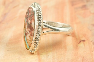 Genuine Boulder Turquoise set in Sterling Silver Ring. The cabachon is Boulder Turquoise, you can see the veins of Turquoise running through the host rock. The Boulder Turquoise Mine is located in northeast Nevada. It was discovered in 1970 by a Shoshone sheep herder. Production is small due to the remote location and winter weather. Boulder Turquoise is valued for both it's beauty and rarity. Every stone is unique. Created by Navajo Artist Arkie Nelson. Signed.