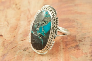 Genuine Sunnyside Turquoise set in Sterling Silver Ring. The matrix on this rare stone is outstanding. The Sunnyside mine is located in northern Nevada near the town of Tuscarora in the Tuscarora mountain range. The mine is no longer in operation as it has become part of a gold mining operation and a privately owned ranch. The Sunnyside mine was mined mostly in the 70's. You won't find much of this great turquoise around anymore except for old stashes. Created by Navajo Artist Margaret Platero. Signed by the artist.