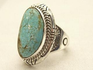 Genuine Number 8 Turquoise set in Sterling Silver Ring. The Number 8 mine is located in Eureka County Nevada. Since 1976 there has been no Number 8 Turquoise mined. There is however, an existing stock pile that Mr. Dowell Ward, the last owner of the Number 8 mine, had stocked away for later sorting. The Turquoise is a collector's item--because once the reserve is gone there will be no more material released onto the market. The Gold Mining Company owns the claim to the Number 8 mine and it has been swallowed up by the gold mining operations. This is some of the last Number 8 Turquoise to be had and will be a great addition to your collection. Created by Navajo Artist Larson Lee. Signed.