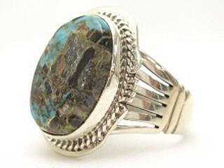 Genuine Sunnyside Turquoise set in Sterling Silver Ring. The matrix on this rare stone is outstanding. The Sunnyside mine is located in northern Nevada near the town of Tuscarora in the Tuscarora mountain range. The mine is no longer in operation as it has become part of a gold mining operation and a privately owned ranch. The Sunnyside mine was mined mostly in the 70's. You won't find much of this great turquoise around anymore except for old stashes. Created by Navajo Artist Kathy Yazzie. Signed. 
