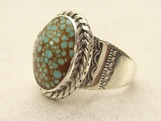 Genuine Number 8 Turquoise set in Sterling Silver Ring. The Number 8 mine is located in Eureka County Nevada. Since 1976 there has been no Number 8 Turquoise mined. There is however, an existing stock pile that Mr. Dowell Ward, the last owner of the Number 8 mine, had stocked away for later sorting. The Turquoise is a collector's item--because once the reserve is gone there will be no more material released onto the market. The Gold Mining Company owns the claim to the Number 8 mine and it has been swallowed up by the gold mining operations. This is some of the last Number 8 Turquoise to be had and will be a great addition to your collection. Created by Navajo Artist Bobby Piaso. Signed.