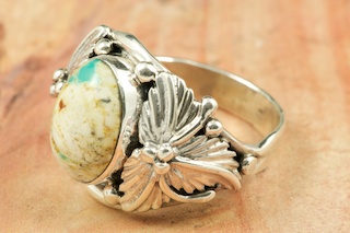 Genuine Boulder Turquoise set in Sterling Silver Ring. The cabachon is Boulder Turquoise, you can see the veins of Turquoise running through the host rock. The Boulder Turquoise Mine is located in northeast Nevada. It was discovered in 1970 by a Shoshone sheep herder. Production is small due to the remote location and winter weather. Boulder Turquoise is valued for both it's beauty and rarity. Every stone is unique. Created by Navajo Artist Bobby Piaso. Signed by the artist.