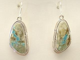 Authentic Native American Jewelry. Genuine Boulder Turquoise set in Sterling Silver French Wire Earrings. The cabachons are of Boulder Turquoise, you can see the veins of Turquoise running through the host rock. The Boulder Turquoise Mine is located in northeast Nevada. It was discovered in 1970 by a Shoshone sheep herder. Production is small due to the remote location and winter weather. Boulder Turquoise is valued for both it's beauty and rarity. Every stone is unique. Created by Navajo Artist Lucy Valencia. Signed LJ.

