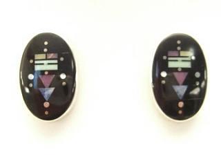 Genuine Jet, Turquoise and Sugilite inlaid in Sterling Silver Post Earrings. Created by Navajo Artist Jimmie Harrison. Signed. Yei gods, midnight galaxy constellations and Navajo landscapes inspire Jimmie in his award winning jewelry designs. May his creations help you walk the Navajo path of beauty.
