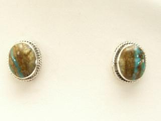 Genuine Boulder Turquoise set in Sterling Silver Post Earrings. The cabachons are of Boulder Turquoise, you can see the veins of Turquoise running through the host rock. The Boulder Turquoise Mine is located in northeast Nevada. It was discovered in 1970 by a Shoshone sheep herder. Production is small due to the remote location and winter weather. Boulder Turquoise is valued for both it's beauty and rarity. Every stone is unique. Created by Navajo Artist Flora Willeto. Signed.