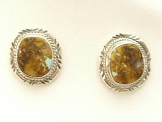 Genuine Boulder Turquoise set in Sterling Silver Post Earrings. The cabachons are of Boulder Turquoise, you can see the veins of Turquoise running through the host rock. The Boulder Turquoise Mine is located in northeast Nevada. It was discovered in 1970 by a Shoshone sheep herder. Production is small due to the remote location and winter weather. Boulder Turquoise is valued for both it's beauty and rarity. Every stone is unique. Created by Navajo Artist Kathy Yazzie. Signed