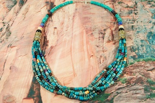 Genuine Assorted Gemstones Necklace. Featuring Genuine Turquoise, Spiny Oyster Shell, Black Onyx, Howlite, Coral and Sugilite. Sterling Silver Barrels, Beads and Clasp. Created by Navajo Artist Tommy Singer. Signed.