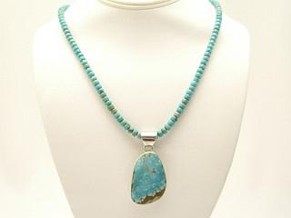 Genuine Number 8 Mine Turquoise Pendant on a Beautiful Necklace featuring Genuine Number 8 Mine Turquoise Stones. Beautiful rolled cut stones with Sterling Silver Cones, Clasp and 4" Extender. Created by Navajo Artist Petra Vandever. The Number 8 Mine Turquoise Pendant was created by Navajo Artist Phillip Sanchez. This is a one of a kind Necklace and Pendant set. The photo is of the jewelry you will be receiving. The Number 8 mine is located in Eureka County Nevada. Since 1976 there has been no Number 8 Turquoise mined. There is however, an existing stock pile that Mr. Dowell Ward, the last owner of the Number 8 mine, had stocked away for later sorting. The Turquoise is a collector's item--because once the reserve is gone there will be no more material released onto the market. The Gold Mining Company owns the claim to the Number 8 mine and it has been swallowed up by the gold mining operations. This is some of the last Number 8 Turquoise to be had and will be a great addition to your collection. The photo is of the necklace you will be receiving. 
