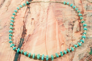Genuine Kingman Turquoise Necklace with Olive Shell Heishi. The Kingman Turquoise Mine is located in the Mineral Park Mining District, Mohave County, Arizona. Created by Santo Domingo Artist Lorraine Cate. Lorraine hand carves the Olive Shell to make the Heishi and added a Turquoise Bead near the clasp as her registered trademark. 