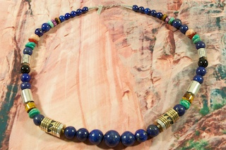 Genuine Turquoise with Accents of Rhodochrosite, Blue Lapis and Picture Jasper. Sterling Silver and Gold Filled Barrels. The photo is of the necklace you will be receiving. Created by Navajo Artist Tommy Singer. Signed.