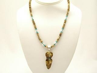 Genuine Boulder Turquoise set in Sterling Silver Pendant, on a Genuine Turquoise and Picture Jasper Necklace. Sterling Silver Clasp and extender. The photo is of the jewelry you will be receiving. The cabochon is Boulder Turquoise, you can see the veins of Turquoise running through the host rock. The Boulder Turquoise Mine is located in northeast Nevada. It was discovered in 1970 by a Shoshone sheep herder. Production is small due to the remote location and winter weather. Boulder Turquoise is valued for both it's beauty and rarity. Every stone is unique. Created by Navajo Artist Larson Lee. Signed.