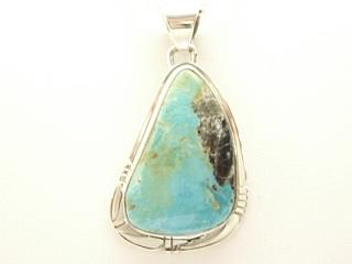 Genuine Sunnyside Turquoise set in Sterling Silver Pendant. Created by Navajo Artist Phillip Sanchez. Signed. The matrix on this rare stone is outstanding. The Sunnyside mine is located in northern Nevada near the town of Tuscarora in the Tuscarora mountain range. Free 18 inch Sterling Silver Chain with purchase of pendant.
