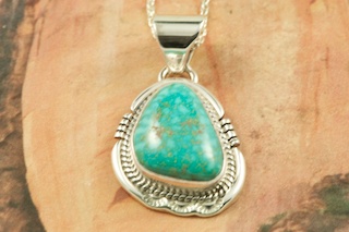 Genuine High Grade Kingman Web Turquoise set in Sterling Silver Pendant. Created by Navajo Artist John Nelson. Signed by the artist. The Mineral Park Mine, in the Cerbat Mountains 14 miles northwest of Kingman, was first mined by Indians centuries before white man came to the area. It is one of the three sites of prehistoric mining localities in the state of Arizona. Mineral Park was the most extensively worked area by the Indians of the three. S.A. �Chuck� Colbaugh found a cache of stone hammers uncovered in ancient trenches and tunnels, when he had the turquoise mining concession in May of 1962. Ithaca Peak and Turquoise Mine (formally called Aztec Mountain or Aztec Peak) are the most famous of the peaks in the area containing turquoise. Free 18